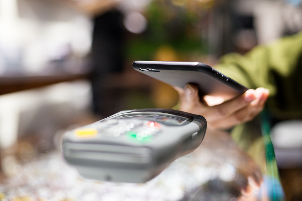 Woman paying with smartphone by NFC-1